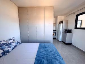 a small room with a bed and a kitchen at Apto no coração de Brusque in Brusque