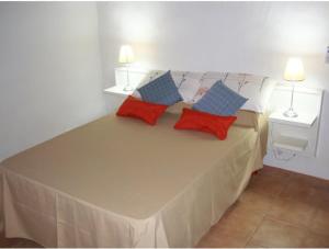 Una cama con almohadas rojas y azules. en Cabañas Calma Chicha, en Cortaderas 48 fotos más