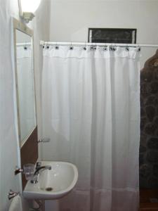 Un baño con lavabo y cortina de ducha. en Cabañas Calma Chicha, en Cortaderas