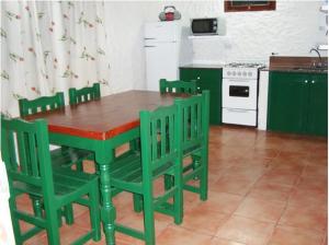una mesa verde y sillas en la cocina en Cabañas Calma Chicha, en Cortaderas