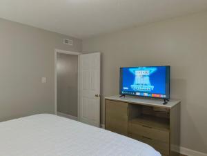 a bedroom with a bed and a flat screen tv at Sand Dollar Motel in Atlantic Beach