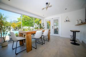a dining room with a wooden table and white chairs at Chic MangoTree villa Private Heated Pool in Fort Lauderdale