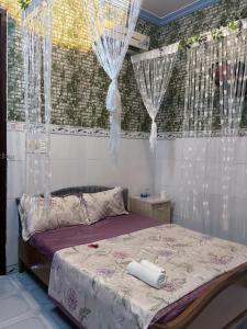 una camera da letto con un letto con tende bianche di Hotel Hải Hà a Phan Thiet