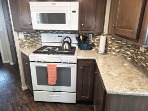 a kitchen with a stove and a microwave at Moab Rim Cabin #16 in Moab