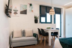 a living room with a couch and a table at Social Lodge Cabouqueira Studios in Funchal +47 photos