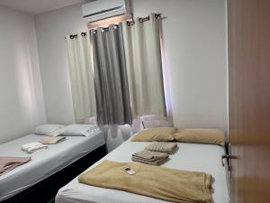 two beds sitting next to each other in a room at Casa de temporada in Trindade