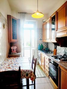 una cucina con armadi in legno e un tavolo con sala da pranzo di Casa Matilda, retro elegance in the center of Monza a Monza