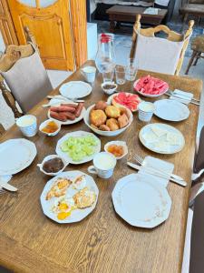 a wooden table with plates of food on it at Hill Haven Guesthouse in Domje