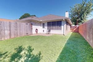 a house with a fence in a yard at Camellia by Wolf Pen in College Station