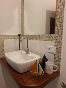 a sink on a wooden counter in a bathroom at Sinta a Ilha mais Bela - 150m das praias do Viana e Siriúba in Ilhabela
