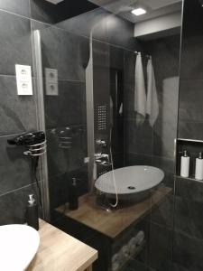a bathroom with a sink and a glass shower at Édes kettes vendégház Demjén in Demjén +29 photos