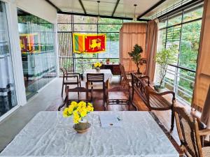 a dining room with a table with yellow flowers on it at Sunset Inn in Kandy