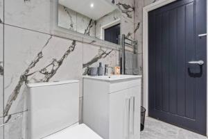 a bathroom with a sink and a blue door at Spacious 5-bed Banbury House near Spiceball Park in Banbury