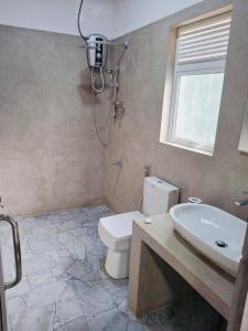 a bathroom with a toilet and a sink and a window at Sunset Inn in Kandy +29 photos