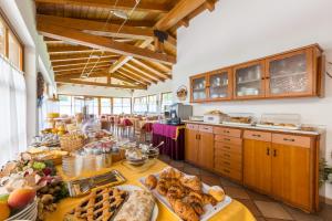 una grande cucina con tavolo pieno di cibo di Hotel Antica Croce - Gardaslowemotion a Tenno