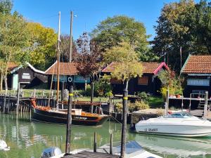 two boats are docked at a dock with houses at Les volets bleus in Brie-sous-Mortagne +41 photos