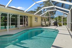 a swimming pool in front of a house at Unwind in tropical paradise at Sunflower Cottage in Sanibel