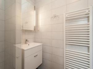 a white bathroom with a sink and a mirror at Holiday Home Groet near Schoorl Dunes in Groet +22 photos