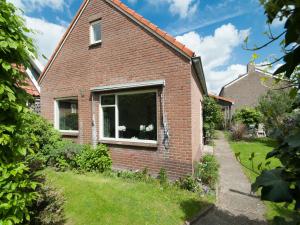 a brick house with a window in a yard at Holiday Home Groet near Schoorl Dunes in Groet