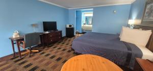 a hotel room with a bed and a desk and a television at Fontana Village Inn in Lake Geneva
