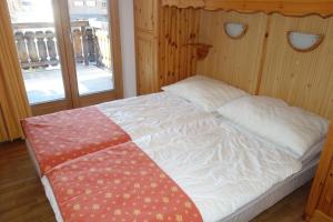 a bedroom with a bed with a white comforter and two windows at Pracondu 2 304 - OUTDOOR & FUN apartment 6 pers in Nendaz