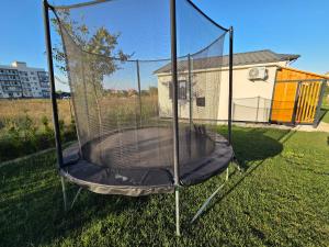 a trampoline with a net in a yard at Căsuța fericită in Techirghiol