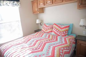 a bedroom with a bed with a colorful blanket at Petroglyph Point Cabin #17 in Moab