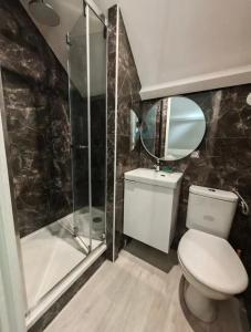 a bathroom with a toilet and a glass shower at Apart Fosses 10 min to PAsterix Airport PARIS 30 min in Fosses