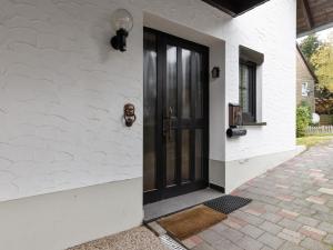 a black door on the side of a white house at Charmantes Refugium mit 2 Schlafzimmern in Olsberg +32 photos