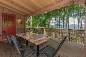un tavolo e sedie in legno su una terrazza di Bearfoot Adventure by American Patriot Getaways a Oldham
