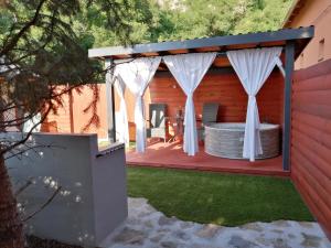a hot tub on a deck with a pergola at Édes kettes vendégház Demjén in Demjén