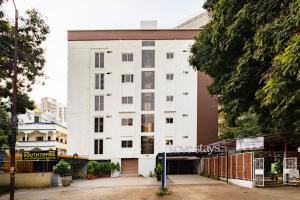 un bâtiment blanc avec un panneau devant dans l'établissement Kove Stays, à Hyderabad