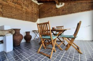 a room with a table and two chairs and a table and a table and chairs at Casa dos Vizinhos - Casas de Taipa in São Pedro do Corval