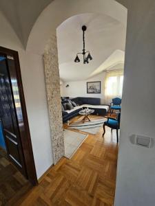 ポドゴリツァにあるApartment Vasilijeのリビングルーム(ソファ付)へと続く廊下 +2枚の写真