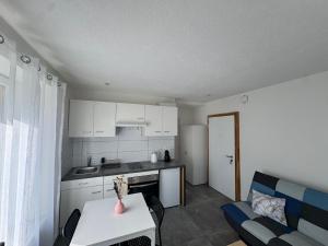 Una cocina y una sala de estar con una mesa y un sofá. en AA - Cosy, en Couvet