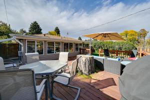 a wooden deck with a table and an umbrella at Less Than 7 Mi to Dtwn Denver Home with Large Yard! in Denver