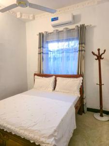 a bedroom with a bed with a cross in front of a window at Ifa Apartment in Kiembi Samaki