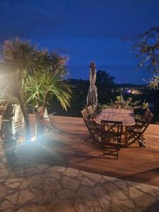 a table and chairs on a wooden deck at night at Chambre d hote in Le Tignet +3 photos