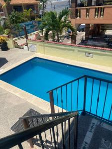 ein großer blauer Swimmingpool neben einem Gebäude in der Unterkunft Casitas Las Palmas - La Brisa in Punta Mita