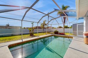 ein Swimmingpool mit einem Sonnenschirm auf dem Dach eines Hauses in der Unterkunft Coral Palm Villa in Cape Coral