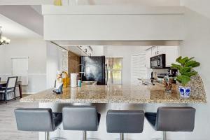 eine Küche mit einer Marmoroberfläche und Stühlen in der Unterkunft Coral Palm Villa in Cape Coral