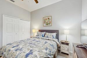 ein Schlafzimmer mit einem Bett mit einer blau-weißen Bettdecke in der Unterkunft Coral Palm Villa in Cape Coral + 15 Fotos