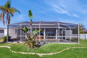 ein Haus mit einem Metalldach und einer Palme in der Unterkunft Coral Palm Villa in Cape Coral
