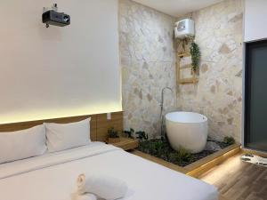a bedroom with a bed and a bath tub at Chạm's Hotel & Homestay in Ho Chi Minh City +84 photos