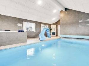 a swimming pool with a slide in a building at 20 person holiday home in Stege in Stege +27 photos