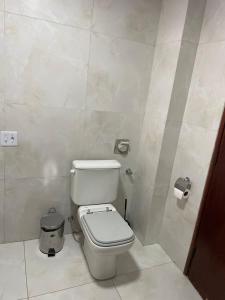 a bathroom with a white toilet in a room at Flat perto da praia com piscina na cobertura in São Vicente