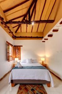 a bedroom with a large bed in a room with wooden ceilings at Casa Bari Altos de la Antigua in Barichara
