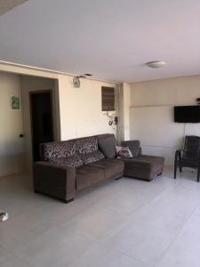 a living room with a couch and a tv at Pousadinha Safira in Sinop