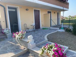 a home with flowers in front of a house at A casa di Giulia in Rosolina