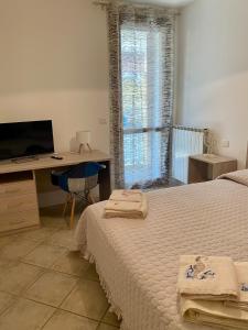 a bedroom with a bed and a desk and a window at A casa di Giulia in Rosolina